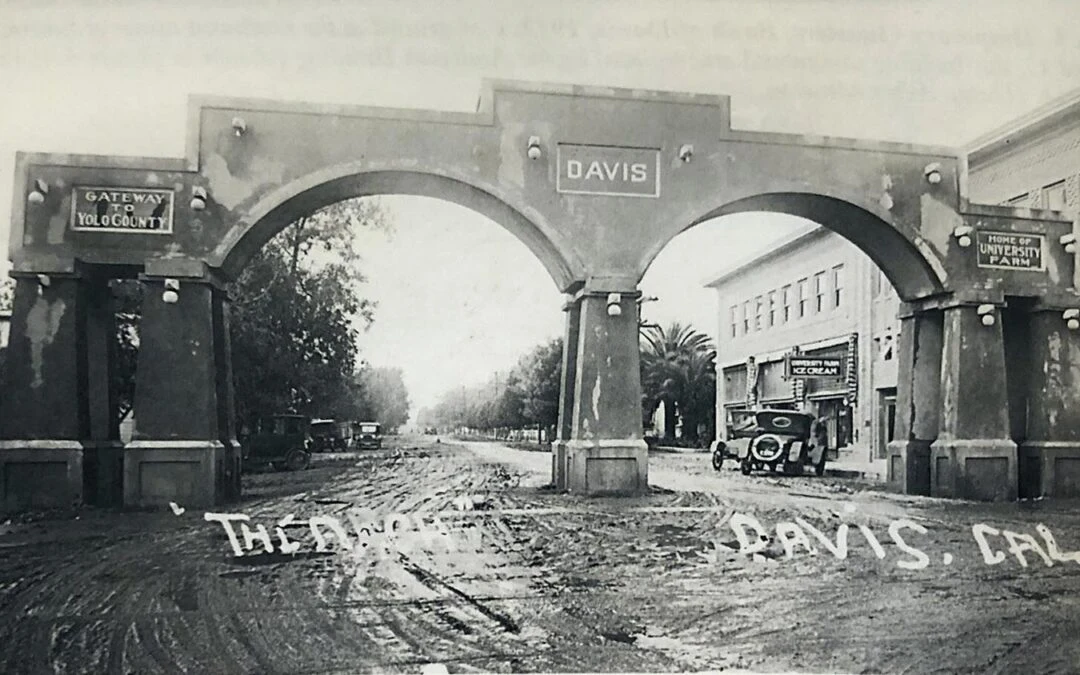 Historic photograph of the Davis street arch and early automobiles